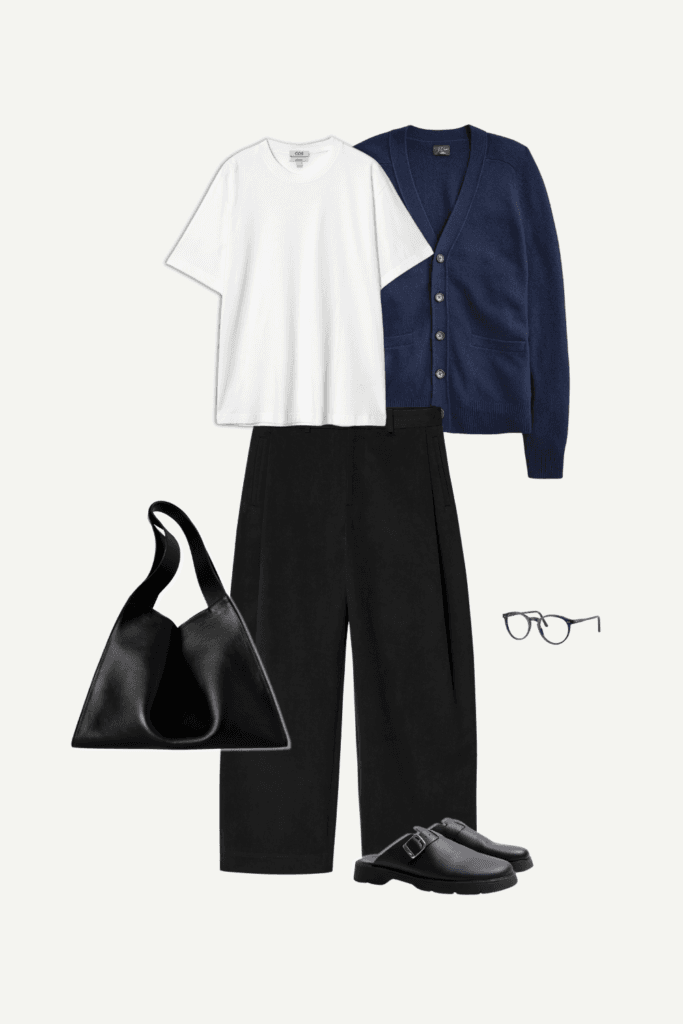 Smart casual minimalist outfit featuring a white T-shirt, navy blue cardigan, and black wide-leg pants with round glasses, black handbag, and black loafers.