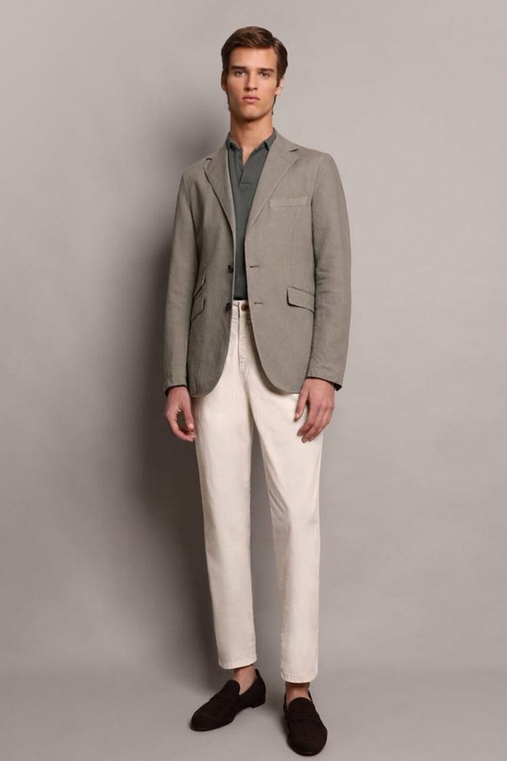 A man wearing beige chinos, a polo shirt or button-down, canvas sneakers or loafers, and an unstructured blazer — a perfect smart casual summer outfit for office days.
