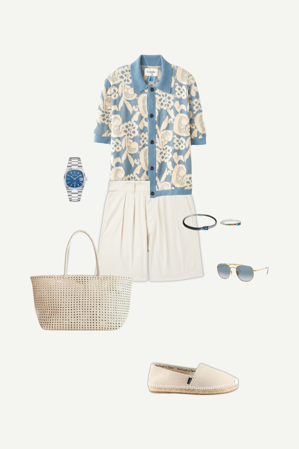 Flat lay of a men’s summer smart casual outfit featuring a floral jacquard polo shirt, pleated shorts, canvas espadrilles, and silver jewelry.